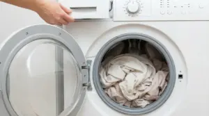 Lenzuola chiare all'interno di una lavatrice con sportello aperto