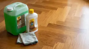 Due flaconi di detergente e un panno in microfibra su un parquet pulito